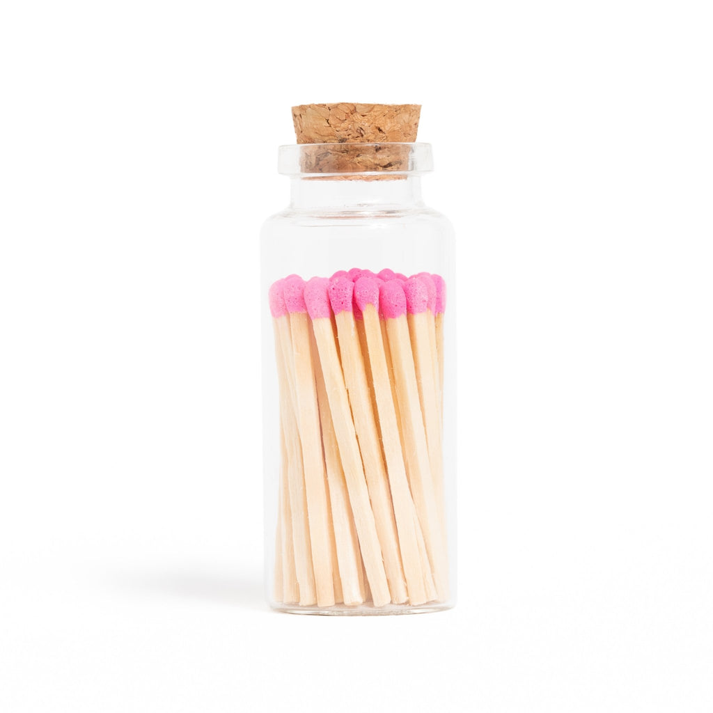 pink matchsticks in corked jar with match striker