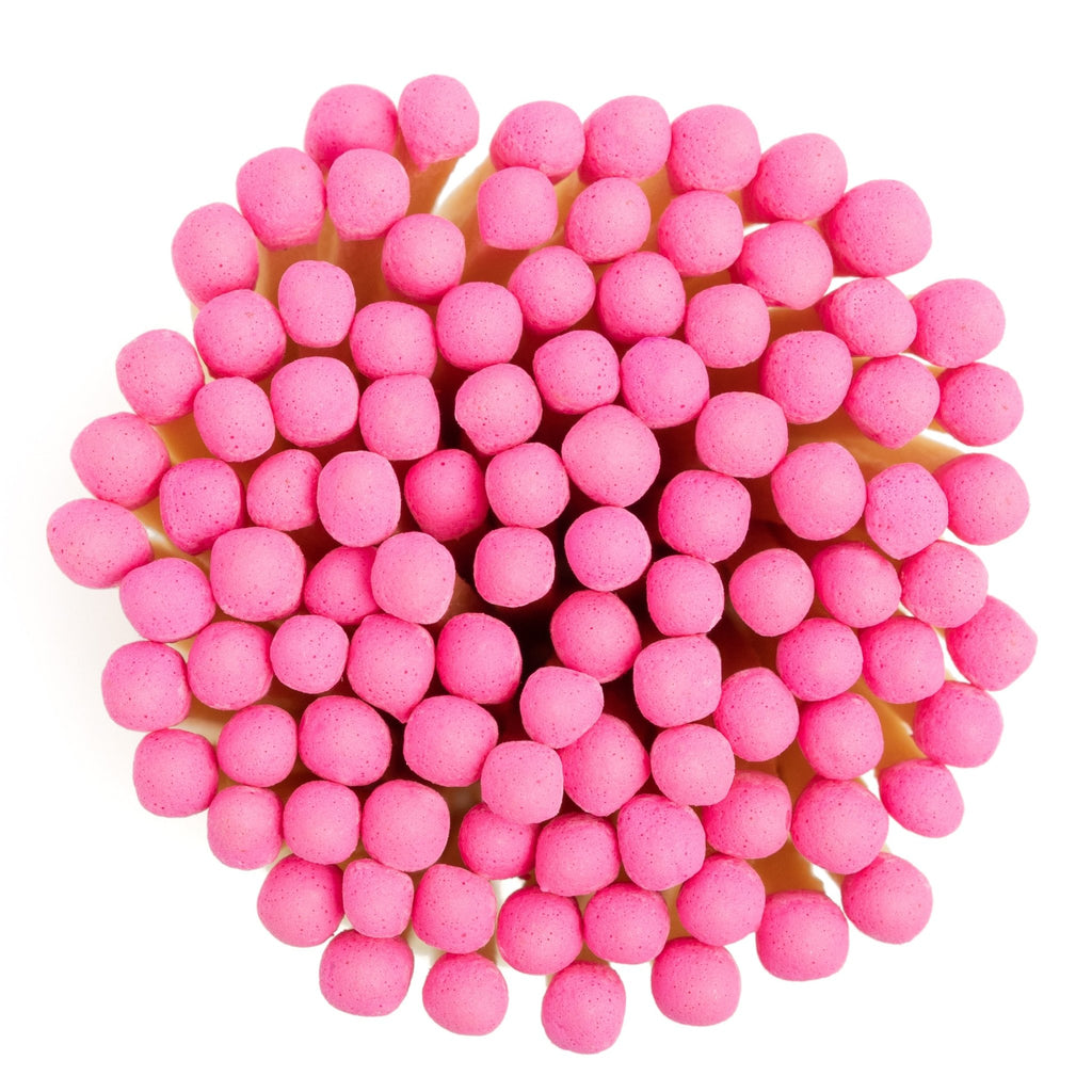 pink matchsticks in corked jar with match striker