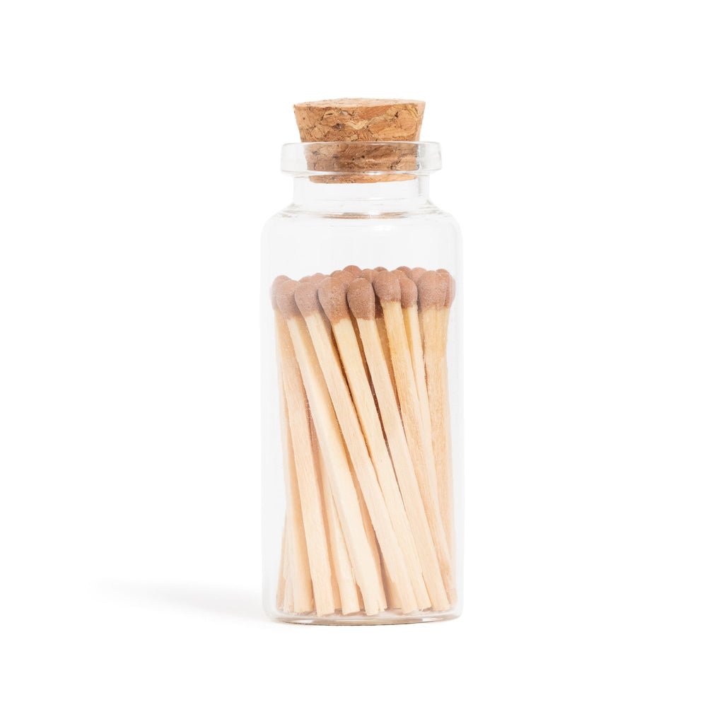 brown matchsticks in corked jar with match striker