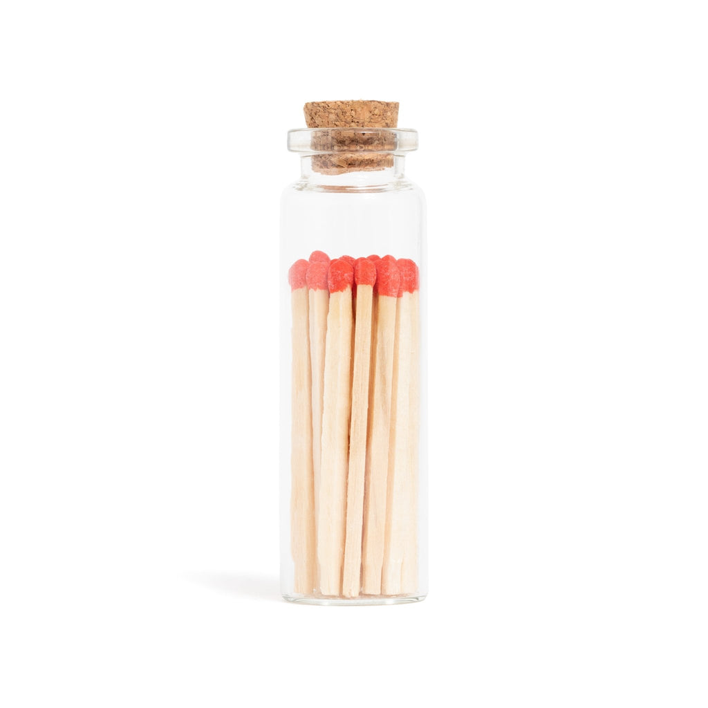 red matchsticks in corked vial with match striker