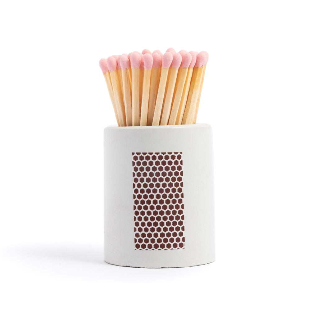 white concrete match jar with colorful matchsticks and match striker