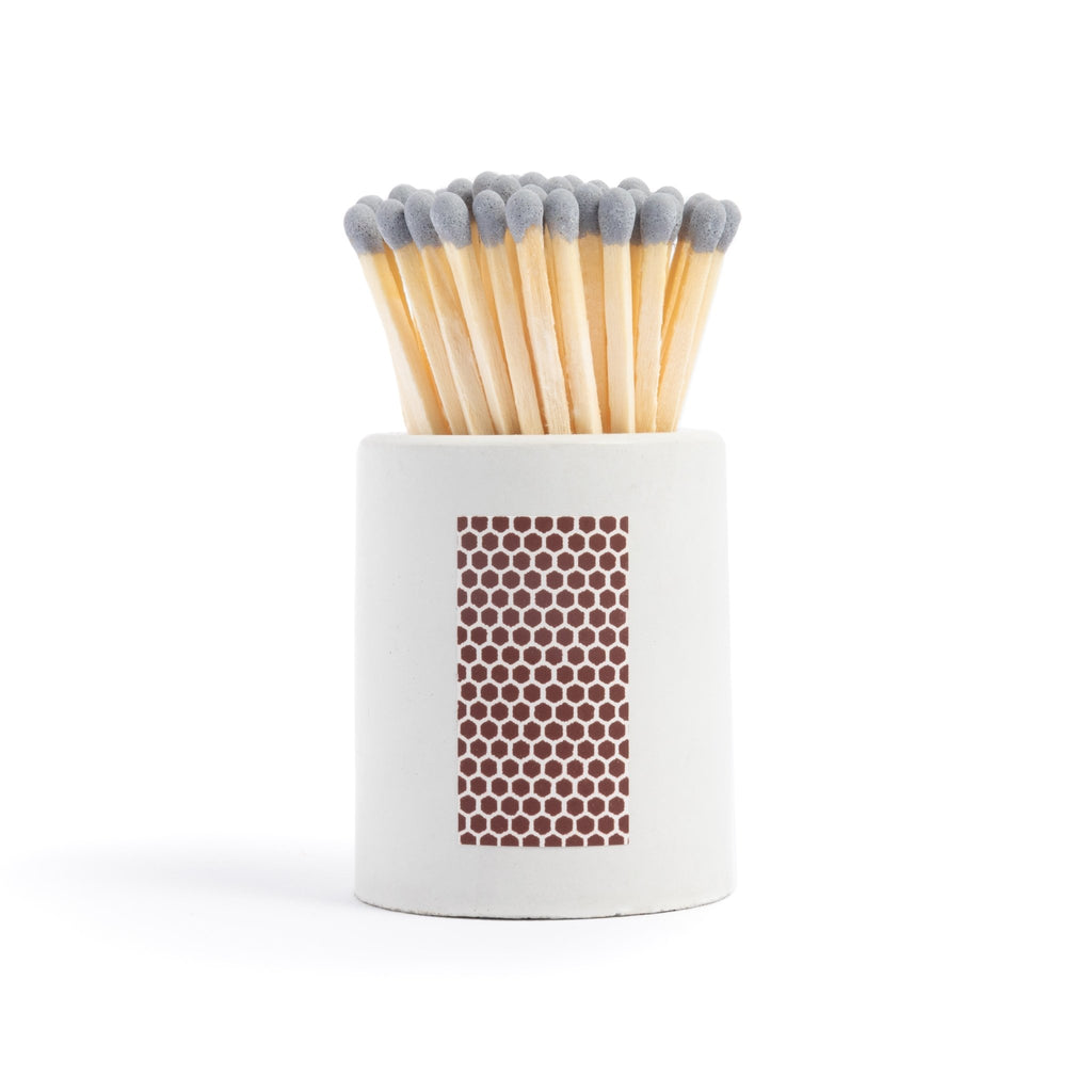 white concrete match jar with colorful matchsticks and match striker
